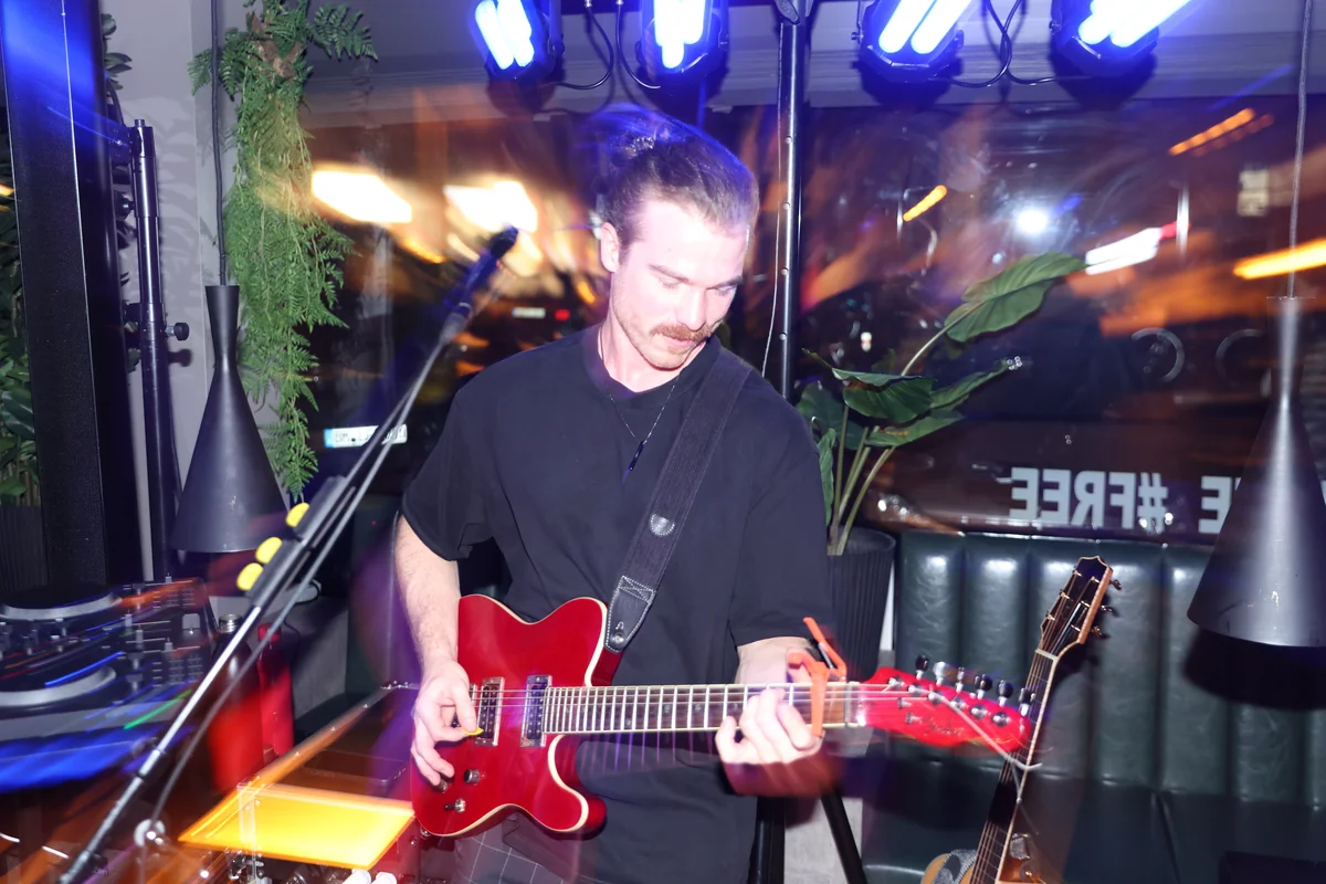 Lars Heermeier mit E-Gitarre und Mikrofon beim Live-Auftritt